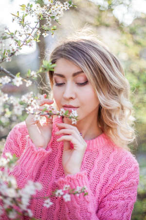 Portrait of a beautiful young woman near a magnolia.