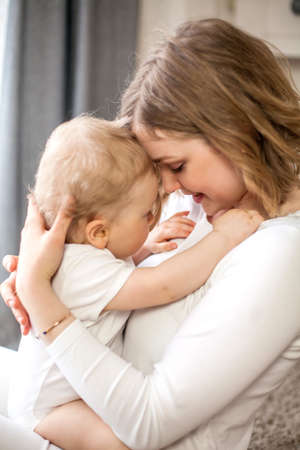 Beautiful mother and little son 9 months in the home interior. Baby. Motherhood.の写真素材