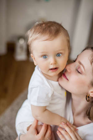 Beautiful mother and little son 9 months in the home interior. Baby. Motherhood.の写真素材
