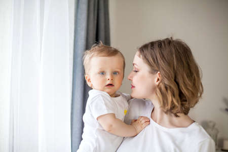 Beautiful mother and little son 9 months in the home interior. Baby. Motherhood.の写真素材