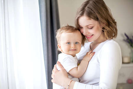 Beautiful mother and little son 9 months in the home interior. Baby. Motherhood.の写真素材