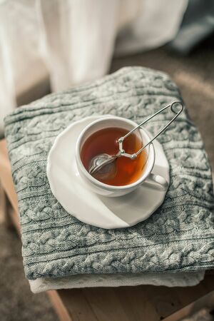 Toned photo. Autumn decor. A mug of hot tea, Knitted sweaters . Cozy. Autumn. Fall mood.の写真素材