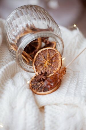 wicker basket, knitted sweater, a beautiful glass jar with dried citruses, Christmas lights.の写真素材