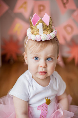 Little girl's first birthday party. Portrait of a girl in a festive dress with an anchor for her first birthday. Baby.の写真素材
