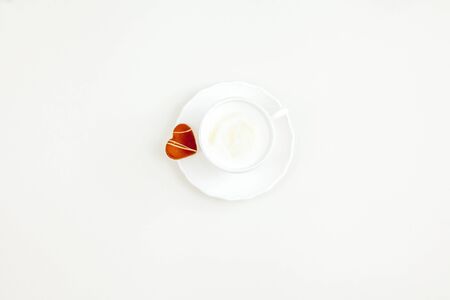 Mug of cappuccino, heart-shaped chocolate chip cookies on a white background. Holidays.の写真素材