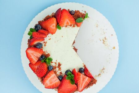 Beautiful cake with berries with butter cream on a blue background. Cake with red cakes. Food.の写真素材