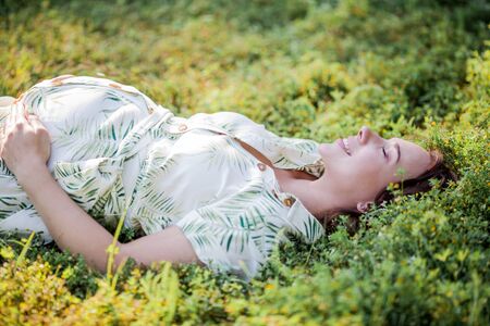 Portrait of a beautiful young pregnant woman in eco dress. Motherhood. A family.の写真素材
