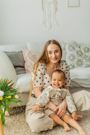 Happy mom and mulatto girl in home interior. Mothers Day.の写真素材