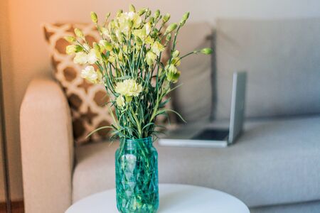 Beautiful stylish interior. The laptop is on the couch, pillow, candles. The cozy corner of the apartment. Spring.の写真素材