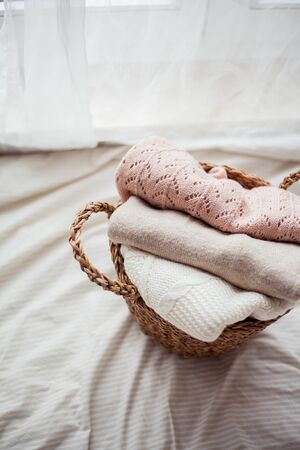 Wicker rattan basket with clothes. Natural organic materials. Homeliness. Cozy.の写真素材