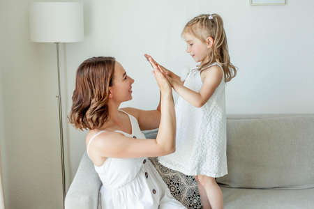 Young happy mother with her daughters in the home interior. Mothers Day. Cozy.の写真素材