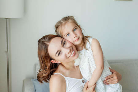 Young happy mother with her daughters in the home interior. Mothers Day. Cozy.の写真素材