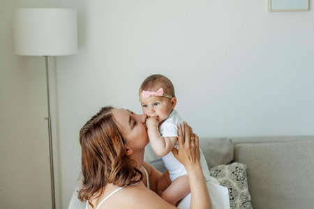 Young happy mother with her daughters in the home interior. Mothers Day. Cozy.の写真素材