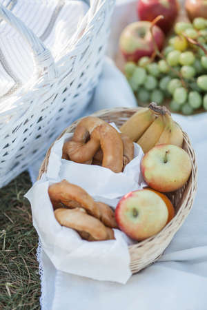 Picnic. Fruit in a basket, a blanket, baked goods in a basket in nature.の写真素材