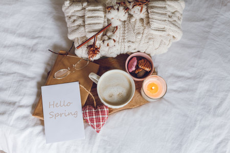 Ecodecor for the home. Home cozy decor. A mug of cappuccino, cookies, a candle on the bed. Winter morning. Holidays.の写真素材