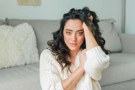 Close up beautiful cozy home portrait of a young beautiful curly woman. Spring.の写真素材