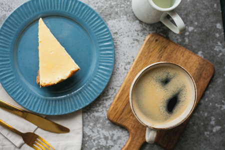 Bakery products. A piece of homemade cheesecake and a mug of coffee.