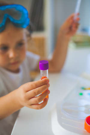 Science. Little cute girl sets up experiments at home, colored liquids, laboratory child's installation. School.の写真素材