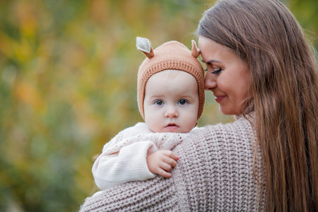 Beautiful young mother with her little daughter 2 years old in green park. happy family. Cosy. fall.の写真素材