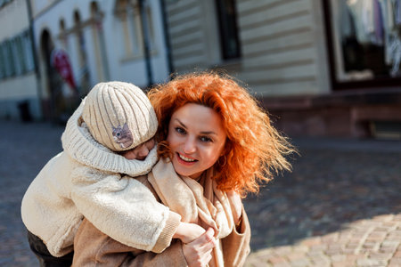 Beautiful young mother and cute little daughter of 4 years old are walking in the center of the old city. Europe. family.の写真素材