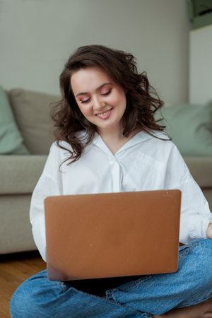 Beautiful young woman works online at home with a laptop. home office. study online. social media. video conversation.の写真素材