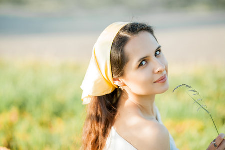 Beautiful young dark-haired woman on picnic in the field. Model in stylish clothes with bicycle.の写真素材