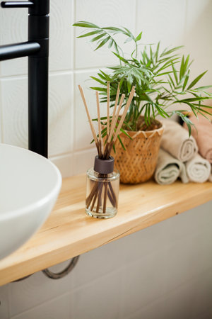 Bathroom in black and white. Home decor. Sink, hand towels, diffuser, house flower.