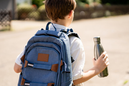 Back to school. Cute happy boy with backpack going to school from home. Cozy.の写真素材