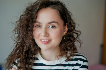 Portrait of young happy beautiful curly woman at home.