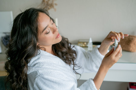 Women's self-care. Young beautiful woman applies nail polish care.の写真素材