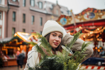 Happy young woman of European appearance at Christmas market in Germany. Festive city. Decor. New Year.の写真素材