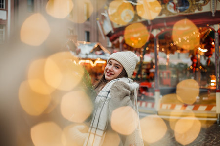 Happy young woman of European appearance at Christmas market in Germany. Festive city. Decor. New Year.の写真素材