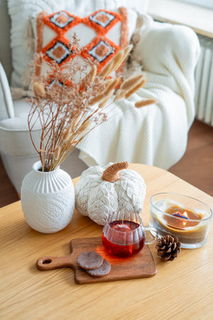 Autumn home decor. Hot tea in glass mug, chocolate cookies, pumpkin, candle.の写真素材