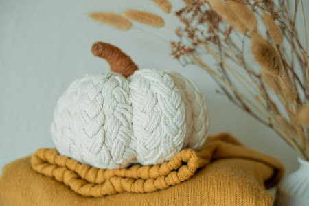 Knitted autumn sweaters on chest of drawers in home interior with pumpkins decor.の写真素材