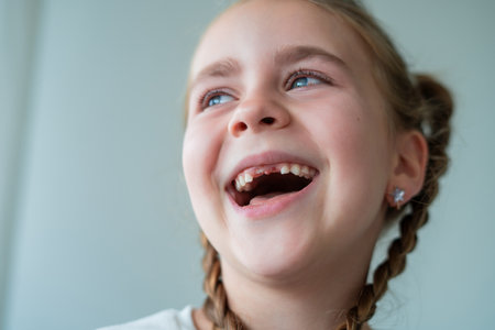 Child lost teeth. Portrait of little girl without teeth. Home.