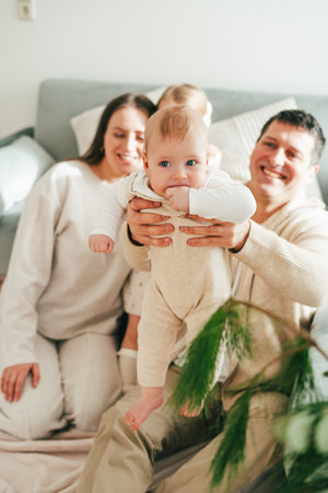 Beautiful happy young family with small children resting at home. Cozy.の写真素材