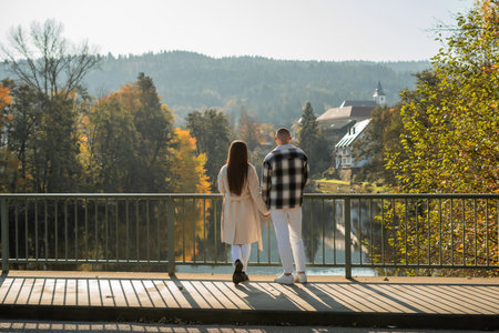 Young couple in love on a bridge by the river in an autumn city.の写真素材