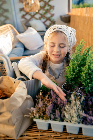 Little girl planting balcony flowers in early autumn. Plant seedlings. Happy child. Home.の写真素材