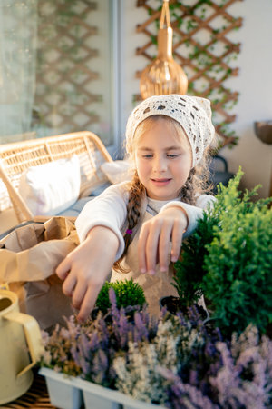 Little girl planting balcony flowers in early autumn. Plant seedlings. Happy child.の写真素材