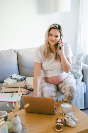 Young pregnant woman working online at home. Freelance.の写真素材