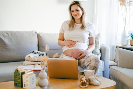 Young pregnant woman working online at home. Freelance.の写真素材