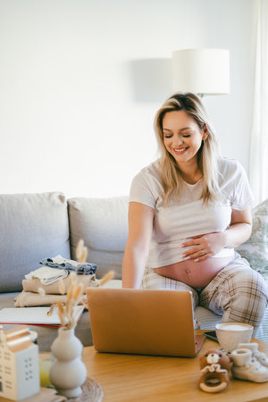 Young pregnant woman working online at home. Freelance.