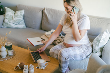 Young pregnant woman working online at home. Freelance.の写真素材