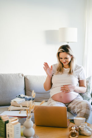 Young pregnant woman working online at home. Freelance.
