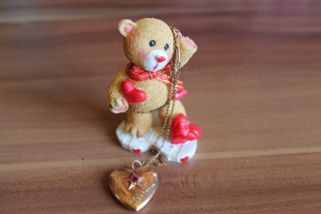 A bear with red hearts and a golden pendant の写真素材