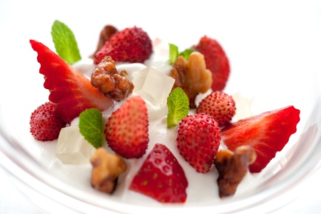 Macro Close up of yogurt ice cream dessert with strawberries and caramalized nut dressingの写真素材