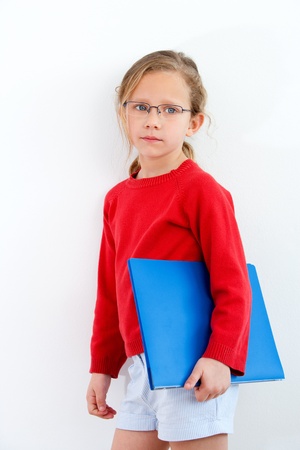 Portrait of cute blond girl holding blue notebook の写真素材