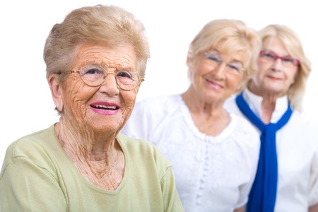 Close up portrait of friendly senior woman with girlfriends in background Isolated on white の写真素材