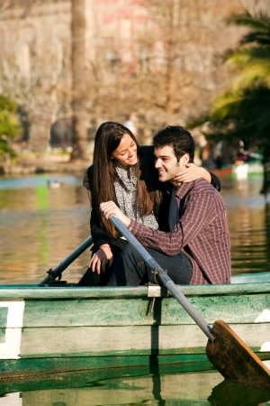 Happy romantic couple rowing a small boat on lake.の写真素材