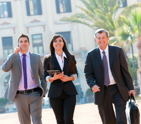 Business colleagues walking outdoors with digital tablet の写真素材